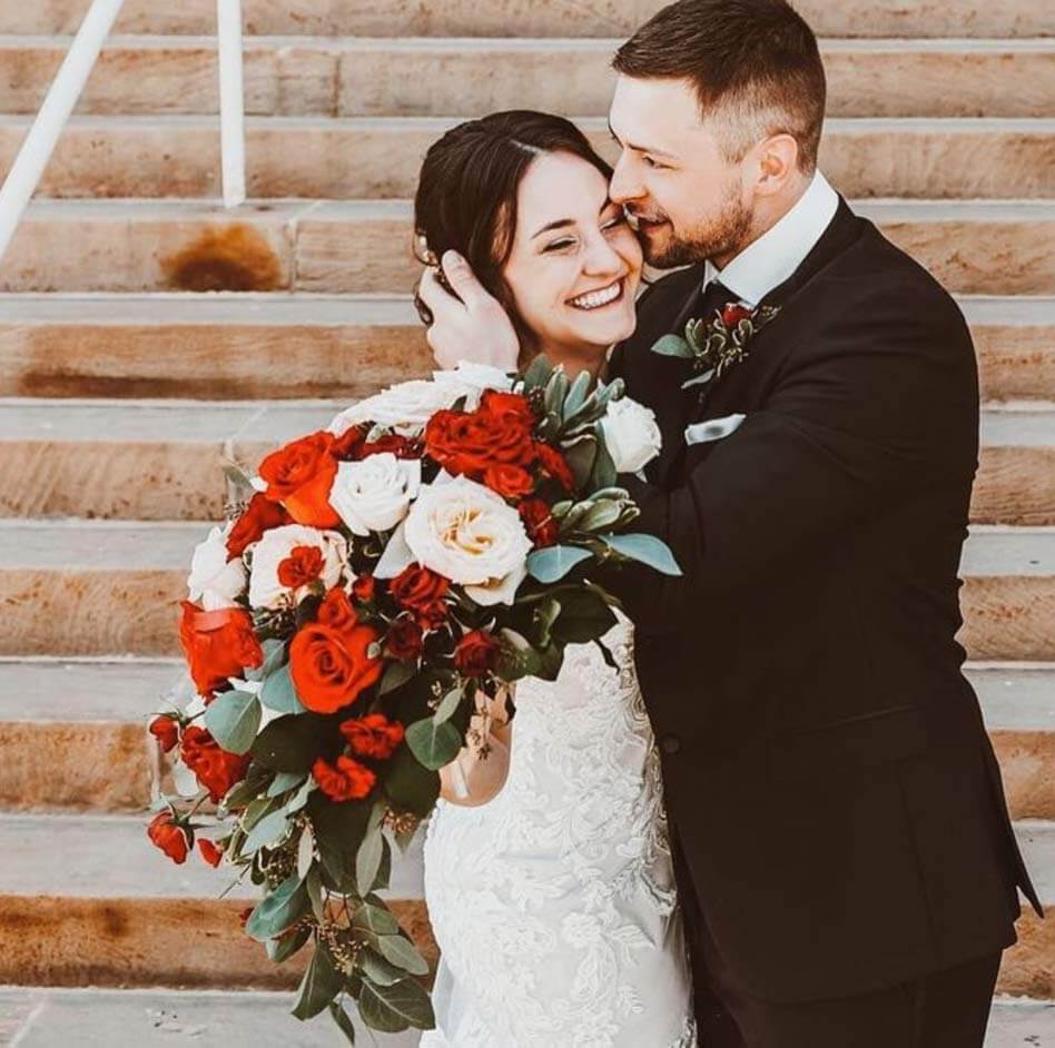 Сouple wearing a white gown and a black suit